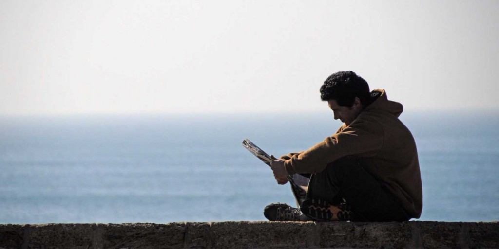 man-reading-on-seawall-2